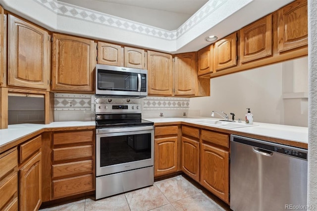 2010 46th Ave Unit 20, Greeley, CO 80634 - kitchen featuring appliances with stainless steel finishes, a sink, light countertops, and decorative backsplash