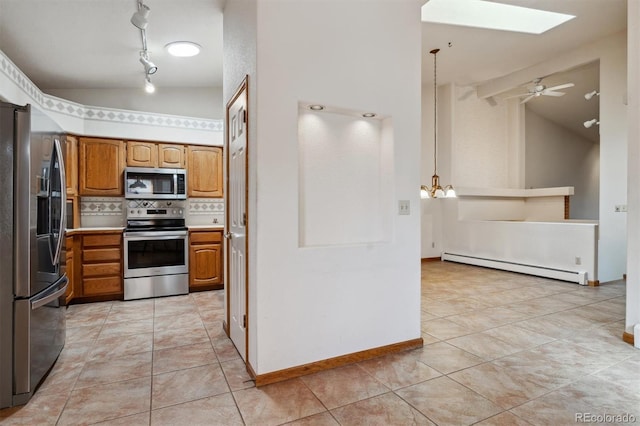 2010 46th Ave Unit 20, Greeley, CO 80634 - kitchen with stainless steel appliances, a baseboard radiator, vaulted ceiling, a skylight, and brown cabinets