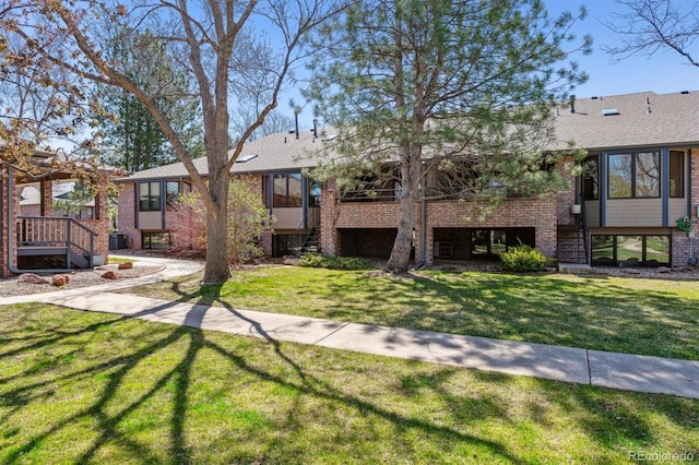 2010 46th Ave Unit 20, Greeley, CO 80634 - view of front of property with stairs, a front lawn, brick siding, and a shingled roof