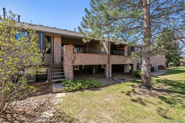 2010 46th Ave Unit 20, Greeley, CO 80634 - rear view of property with a lawn, central AC unit, brick siding, and stairway