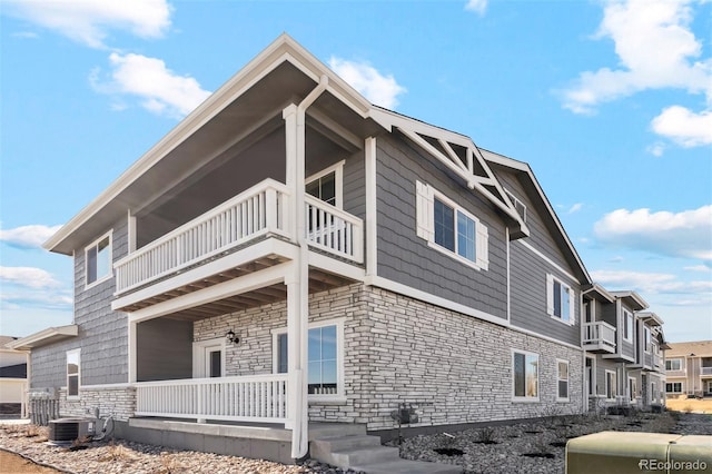 view of home's exterior featuring cooling unit and a balcony