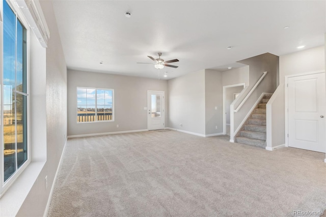 empty room with ceiling fan and light carpet