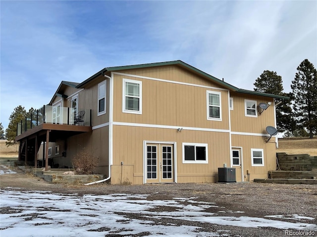 snow covered property featuring cooling unit and french doors