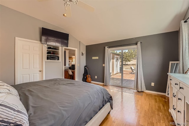 bedroom with baseboards, lofted ceiling, light wood-style floors, and access to exterior