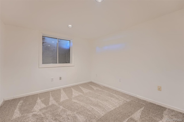 carpeted spare room featuring baseboards