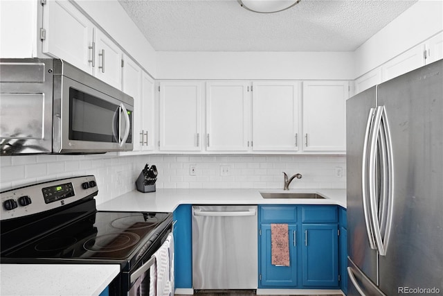 209 Wright St Unit 204, Lakewood, CO 80228 - kitchen with blue cabinets, a sink, stainless steel appliances, white cabinets, and light countertops
