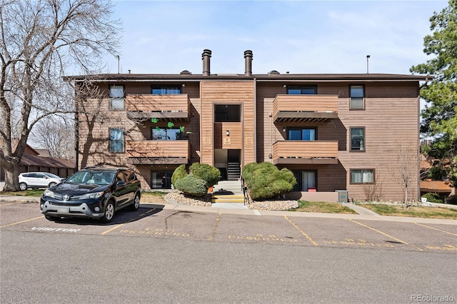 209 Wright St Unit 204, Lakewood, CO 80228 - view of property featuring central AC unit and uncovered parking