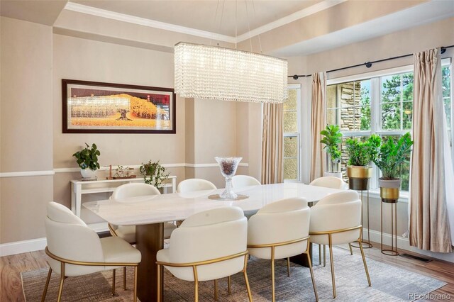 dining room with crown molding, hardwood / wood-style flooring, and an inviting chandelier