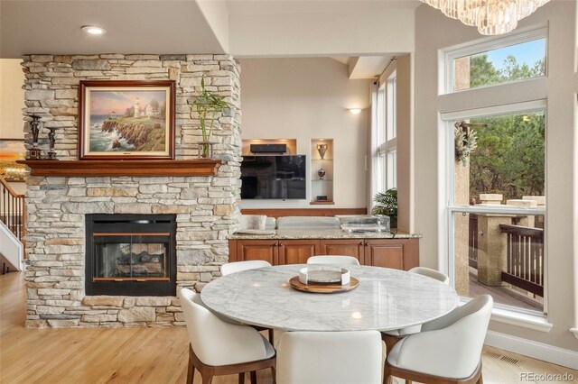 dining area featuring a stone fireplace and light hardwood / wood-style floors