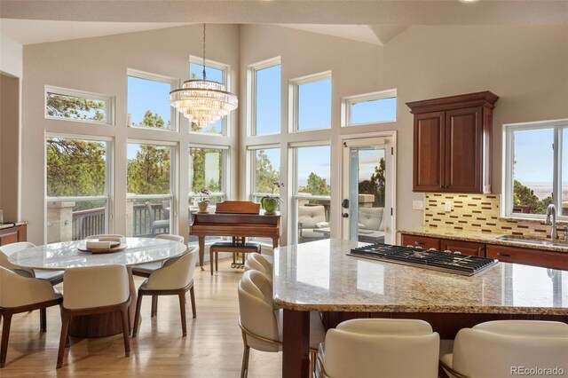 kitchen featuring sink, tasteful backsplash, decorative light fixtures, and a wealth of natural light