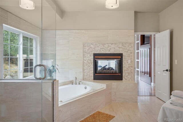 bathroom featuring tile walls, independent shower and bath, and a tile fireplace