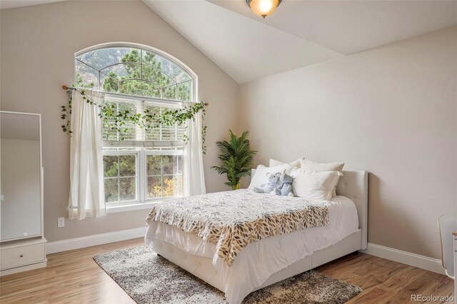 bedroom featuring light hardwood / wood-style floors and vaulted ceiling