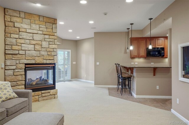 living room featuring light carpet and a stone fireplace