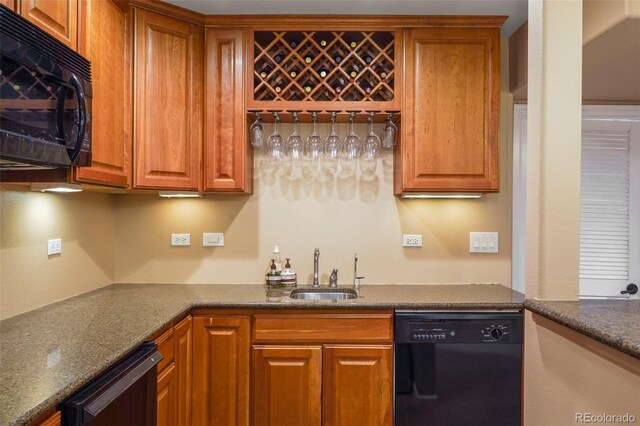 kitchen featuring black appliances, sink, and dark stone counters