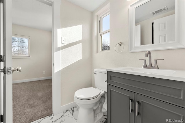 bathroom featuring plenty of natural light, vanity, and toilet