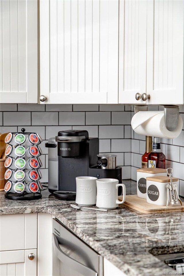 kitchen featuring decorative backsplash, white cabinets, light stone counters, and dishwasher