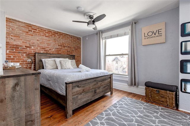 bedroom with brick wall, ceiling fan, and hardwood / wood-style flooring