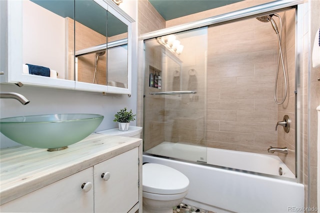 full bathroom featuring vanity, toilet, and bath / shower combo with glass door