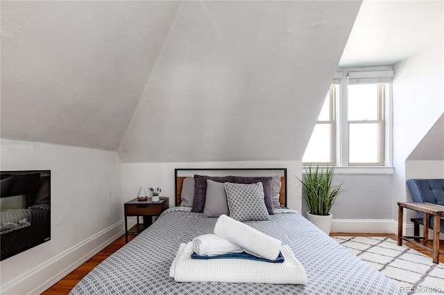 bedroom featuring vaulted ceiling and hardwood / wood-style flooring