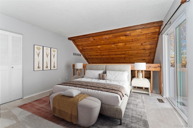 bedroom with wooden ceiling, light colored carpet, a textured ceiling, vaulted ceiling, and a closet