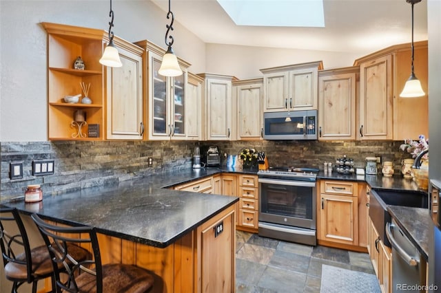 kitchen with tasteful backsplash, hanging light fixtures, stainless steel appliances, and a kitchen breakfast bar