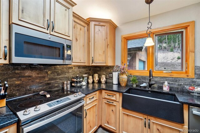 kitchen with sink, decorative light fixtures, backsplash, and appliances with stainless steel finishes