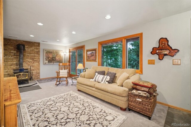 living room featuring light carpet and a wood stove