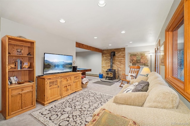 living room featuring light carpet, a baseboard heating unit, and a wood stove