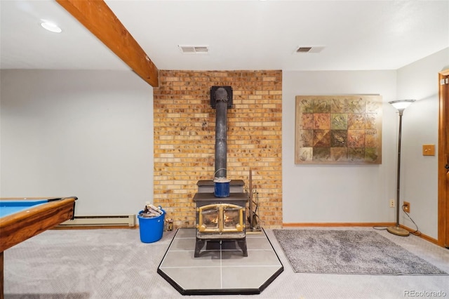 rec room with beamed ceiling, a baseboard radiator, a wood stove, and carpet flooring