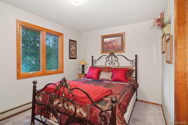 bedroom with light colored carpet and baseboard heating