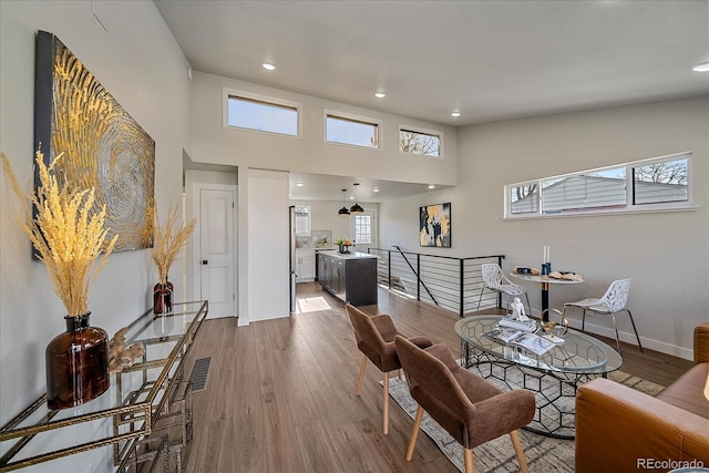 sitting room featuring a high ceiling and hardwood / wood-style floors