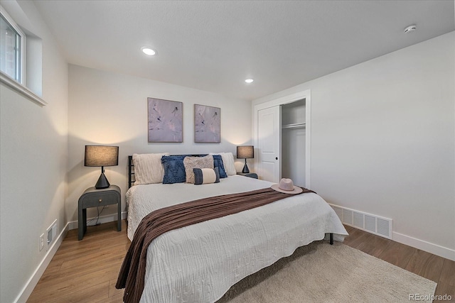 bedroom with wood-type flooring and a closet