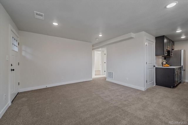 unfurnished living room featuring light colored carpet