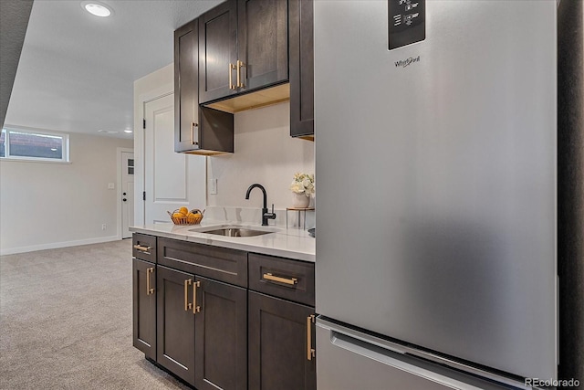 kitchen with sink, light colored carpet, stainless steel fridge, and dark brown cabinetry