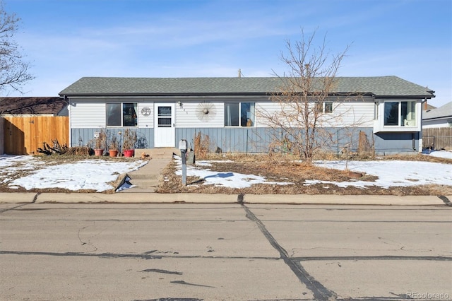 view of front of property with fence and roof with shingles