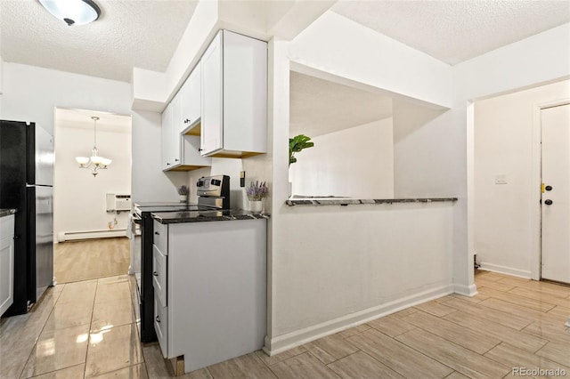 kitchen featuring black refrigerator, range with electric stovetop, a baseboard radiator, decorative light fixtures, and white cabinetry