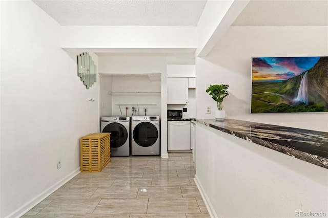 laundry area with a textured ceiling and washer and clothes dryer