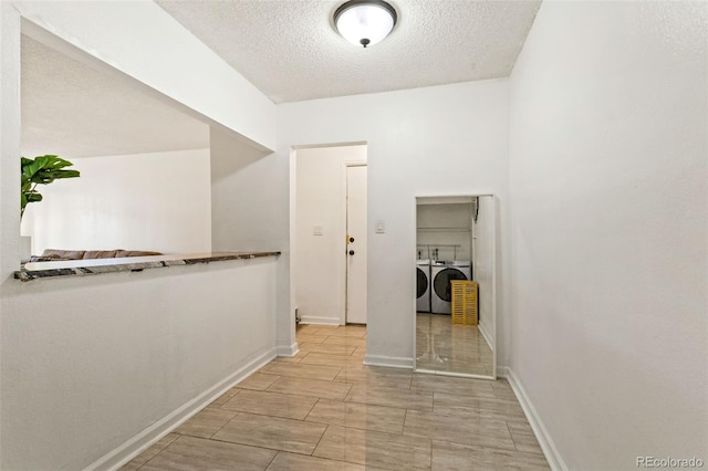 corridor featuring separate washer and dryer and a textured ceiling