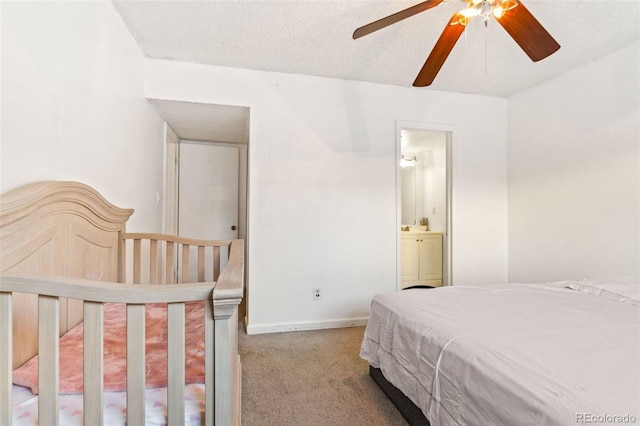 carpeted bedroom featuring ceiling fan, a textured ceiling, and ensuite bath