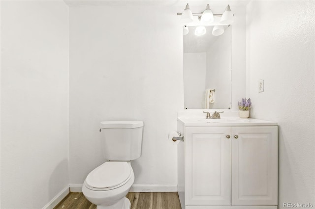 bathroom with wood-type flooring, vanity, and toilet