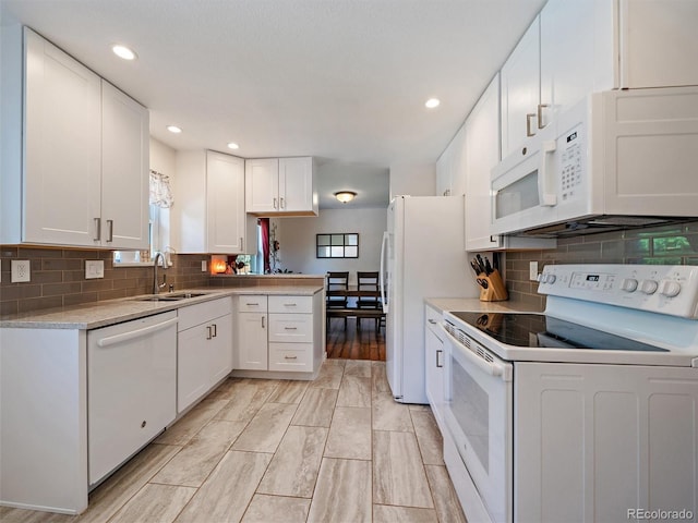 11399 Kendall St, Westminster, CO 80020 - kitchen featuring white appliances, white cabinetry, a peninsula, recessed lighting, and backsplash