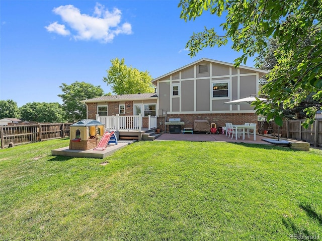 11399 Kendall St, Westminster, CO 80020 - rear view of house with brick siding, a fenced backyard, a wooden deck, and a patio