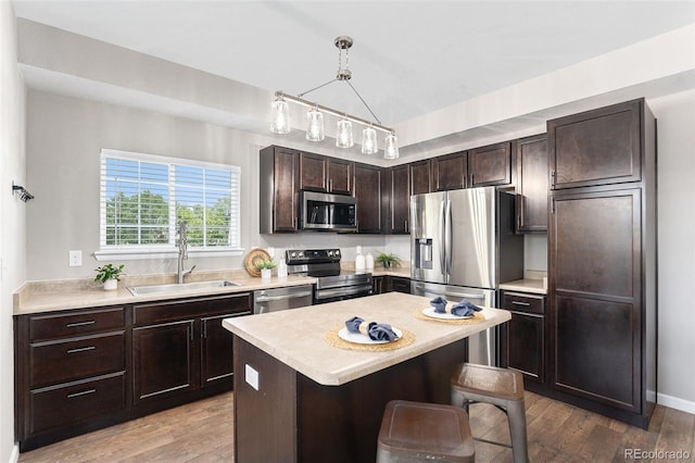 15800 E 121st Ave Unit 3, Brighton, CO 80603 - kitchen with appliances with stainless steel finishes, dark brown cabinets, light countertops, a breakfast bar, and wood finished floors