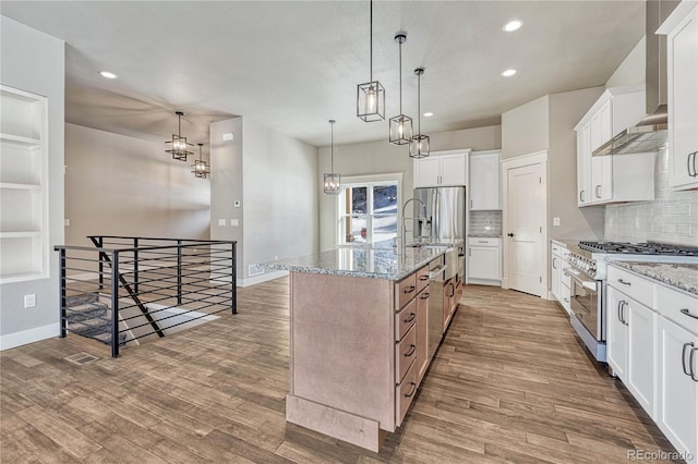 kitchen with white cabinetry, an island with sink, light stone counters, and high end range