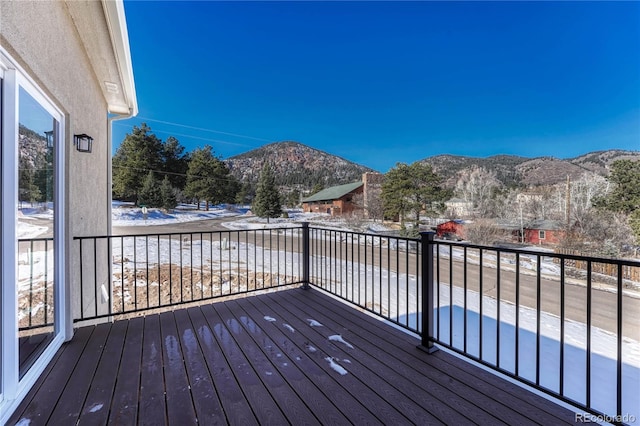 snow covered deck with a mountain view