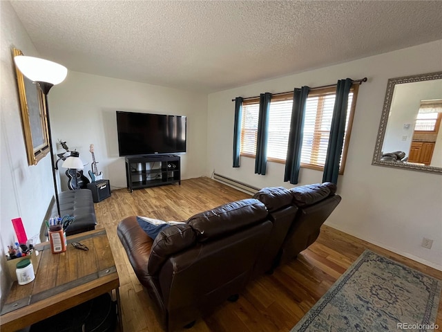 living area featuring a textured ceiling, baseboard heating, and wood finished floors