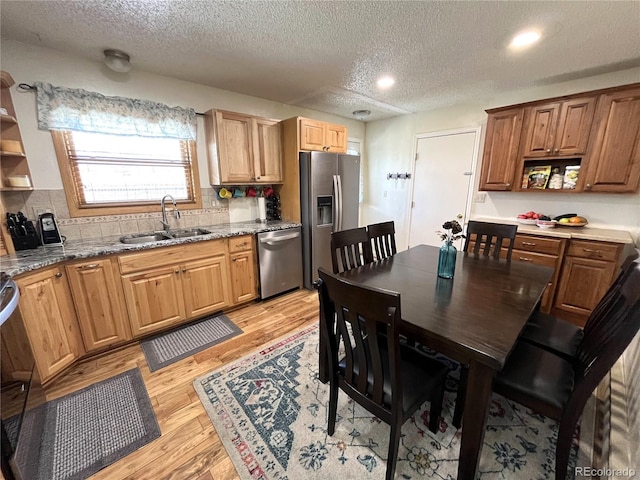 kitchen featuring a sink, stainless steel appliances, light wood-type flooring, and open shelves