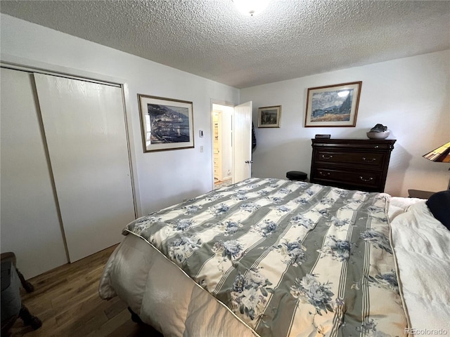 bedroom featuring a textured ceiling, a closet, and wood finished floors