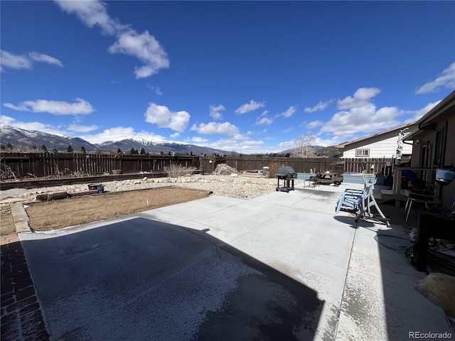 view of patio / terrace featuring a fenced backyard and a mountain view