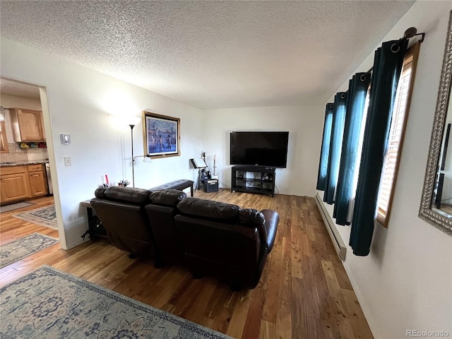 living area with light wood-style flooring and a textured ceiling